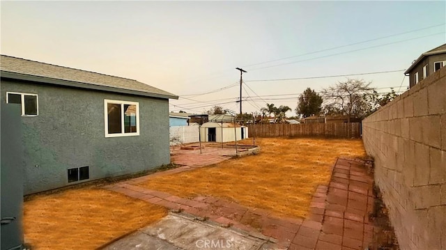 yard at dusk with a patio area