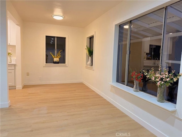 hallway with light hardwood / wood-style floors