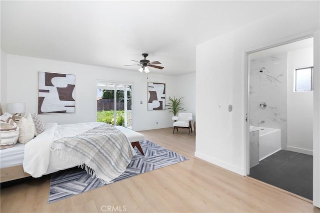 bedroom with access to outside, wood finished floors, baseboards, and multiple windows