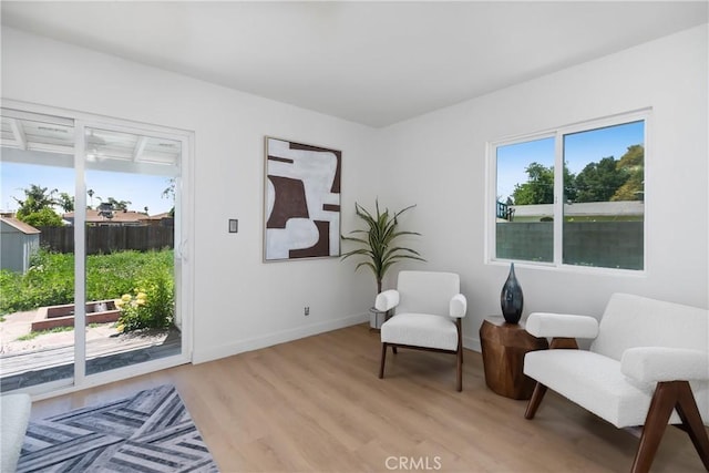 living area featuring light wood-style flooring and baseboards