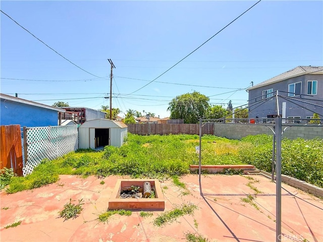 view of yard featuring a garden, a storage shed, a fenced backyard, and an outbuilding