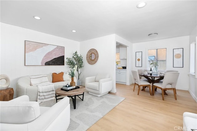 living room with light wood finished floors and recessed lighting
