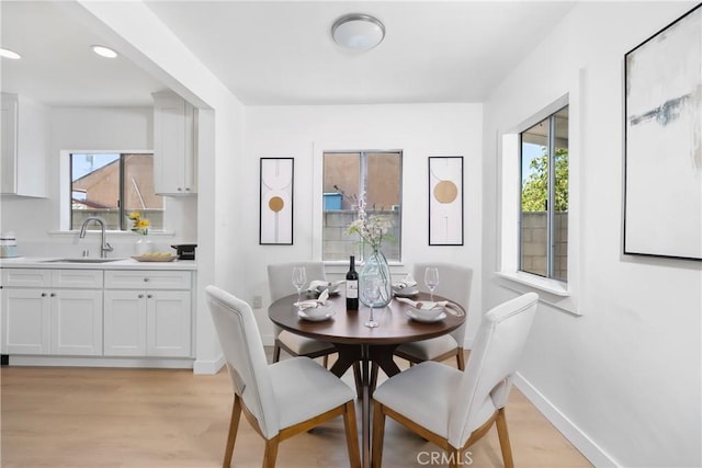 dining space with light wood-style floors, baseboards, and recessed lighting