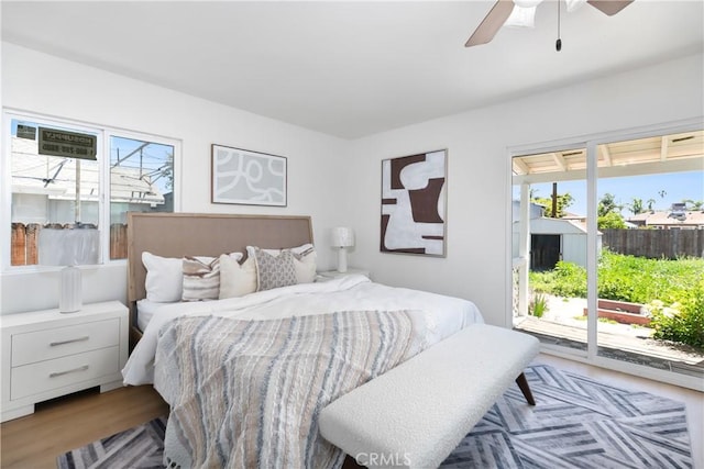 bedroom with access to exterior, wood finished floors, and ceiling fan