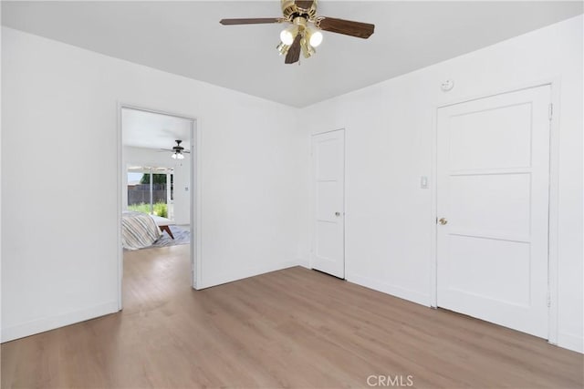 unfurnished room featuring light wood-style floors, baseboards, and a ceiling fan