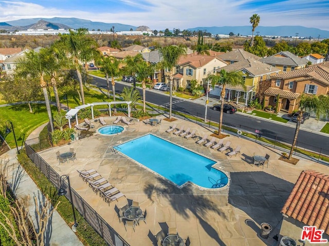 view of swimming pool with a mountain view, a hot tub, and a patio