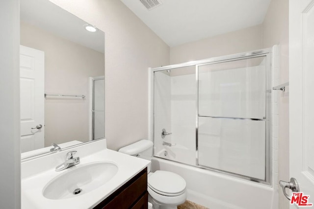 full bathroom with toilet, vanity, and bath / shower combo with glass door