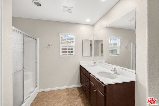 bathroom featuring tile patterned flooring, vanity, and an enclosed shower