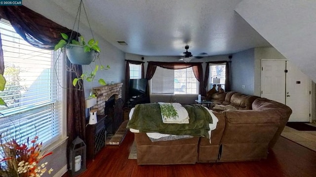 living room with ceiling fan, dark hardwood / wood-style flooring, and a brick fireplace