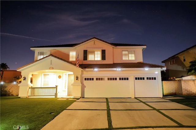 view of front of property featuring a garage, a porch, concrete driveway, and stucco siding