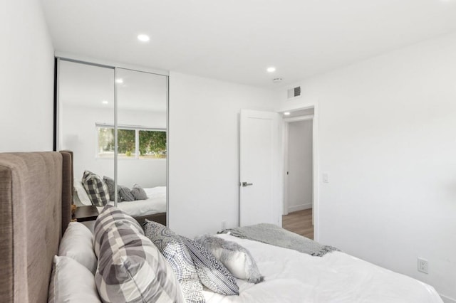 bedroom with wood-type flooring and a closet