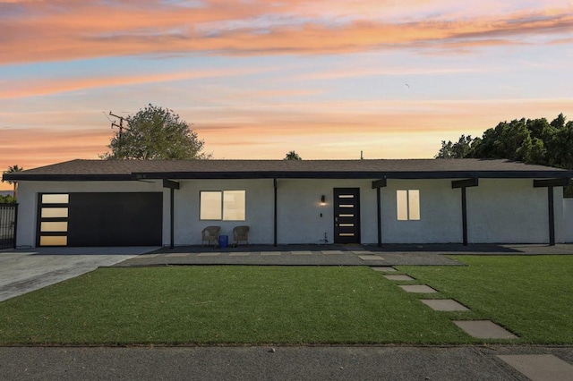 view of front facade with a yard and a garage