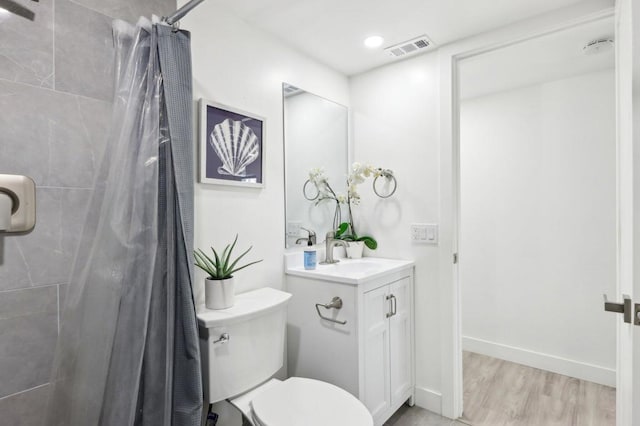 bathroom with a shower with curtain, vanity, hardwood / wood-style floors, and toilet