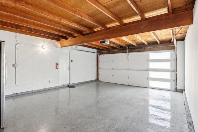 garage featuring stainless steel refrigerator and a garage door opener