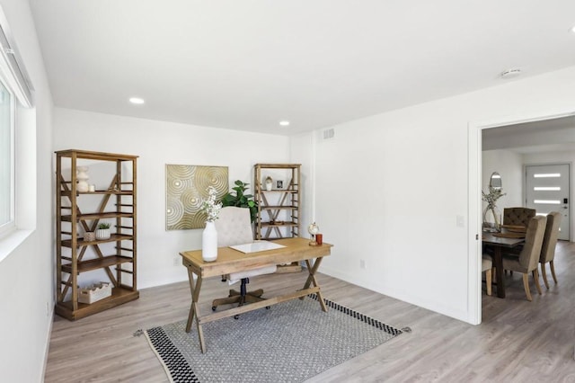 home office with light hardwood / wood-style floors