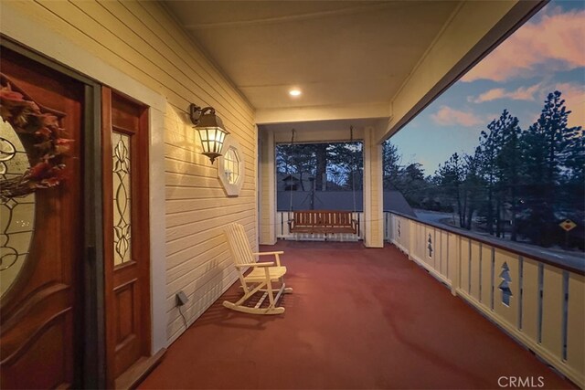 patio terrace at dusk featuring a porch