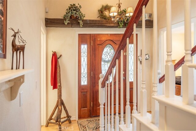 foyer entrance featuring light hardwood / wood-style floors and a chandelier