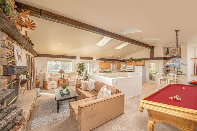 playroom featuring a stone fireplace, vaulted ceiling with skylight, light carpet, and pool table