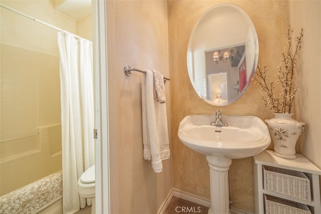 full bathroom featuring toilet, shower / bath combo with shower curtain, and a sink