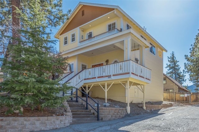 view of front of home featuring fence and stairway