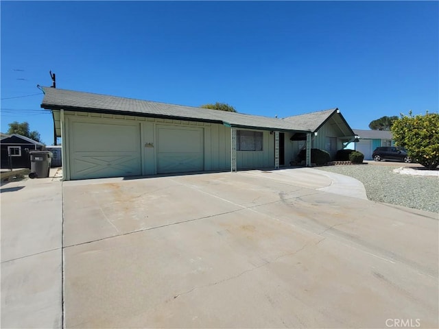 ranch-style home with board and batten siding and concrete driveway