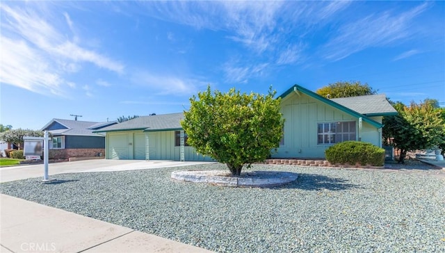 view of front of property with board and batten siding, driveway, and an attached garage