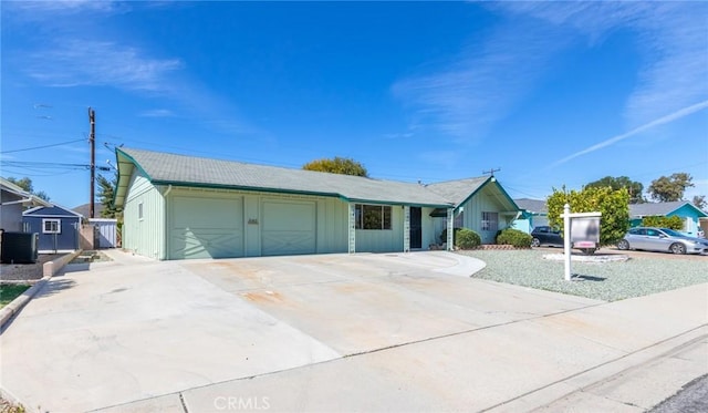 ranch-style house featuring driveway, a garage, and central AC unit