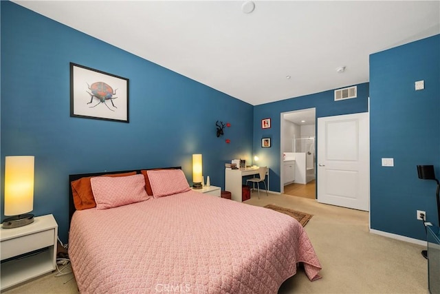 bedroom featuring ensuite bath and light colored carpet