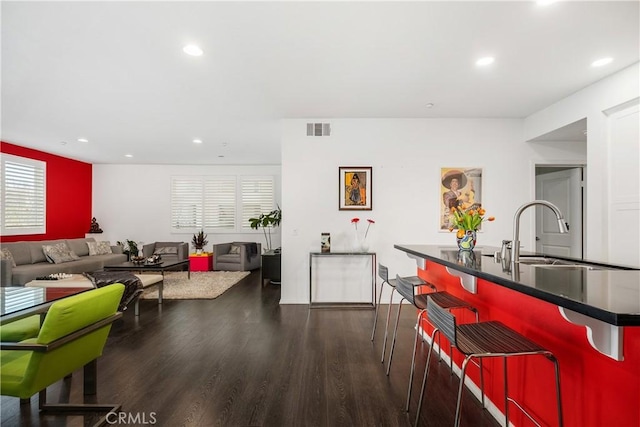 kitchen featuring dark hardwood / wood-style flooring, sink, and a breakfast bar area