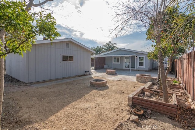 back of property with an outdoor fire pit and a patio area