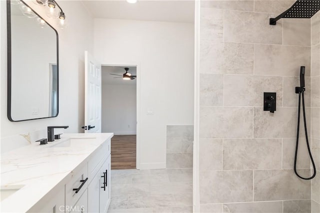 bathroom featuring ceiling fan, tiled shower, and vanity