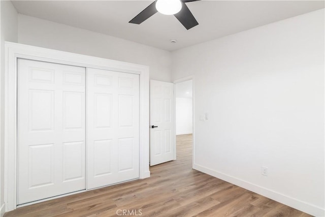 unfurnished bedroom with light hardwood / wood-style flooring, a closet, and ceiling fan