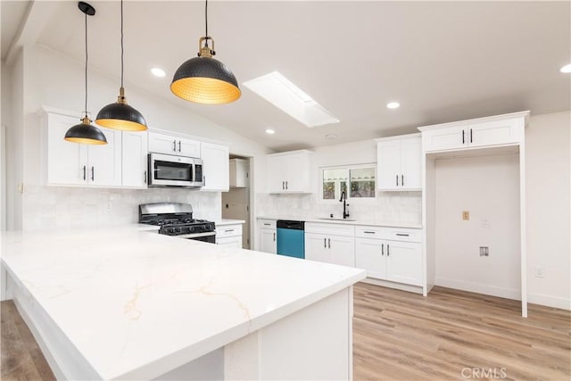 kitchen featuring sink, appliances with stainless steel finishes, white cabinets, decorative light fixtures, and kitchen peninsula