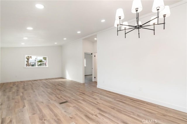 unfurnished room with light hardwood / wood-style flooring and a chandelier