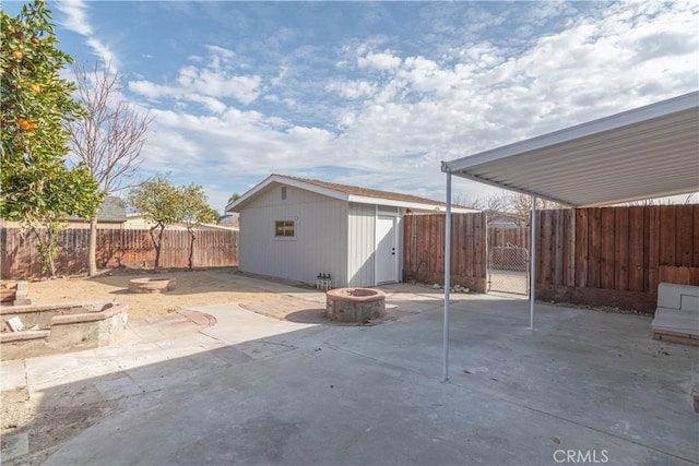 view of patio / terrace with a storage shed and a fire pit