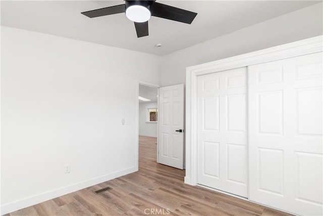 unfurnished bedroom featuring a closet, ceiling fan, and light hardwood / wood-style flooring