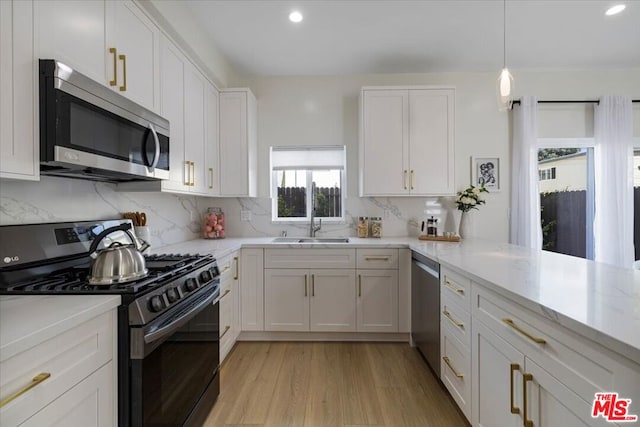 kitchen featuring stainless steel appliances, sink, and white cabinets