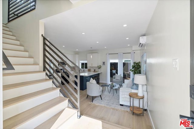 stairs featuring wood-type flooring and an AC wall unit