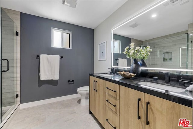 bathroom featuring vanity, a shower with door, and toilet