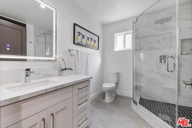 bathroom featuring vanity, a shower with shower door, and toilet