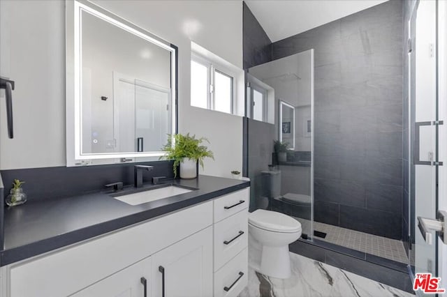 bathroom featuring tiled shower, vanity, and toilet