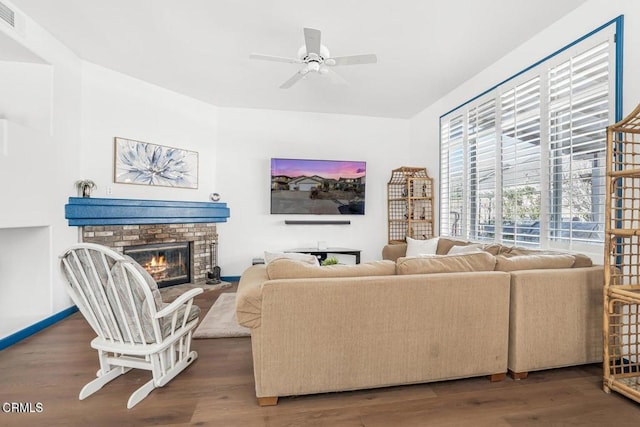 living room featuring dark hardwood / wood-style flooring, a fireplace, and ceiling fan