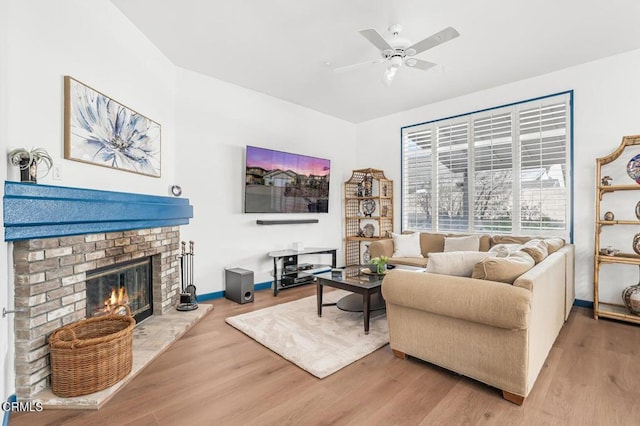 living room featuring hardwood / wood-style flooring, a fireplace, and ceiling fan