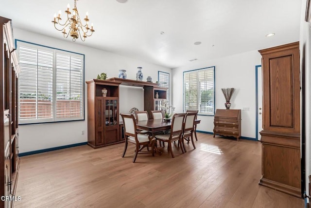 dining area featuring a notable chandelier and light wood-type flooring