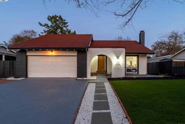 view of front of home featuring a garage and a lawn