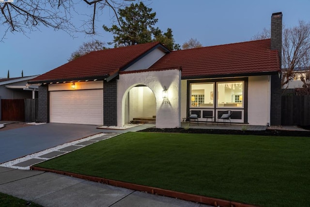 view of front of house featuring a garage and a lawn