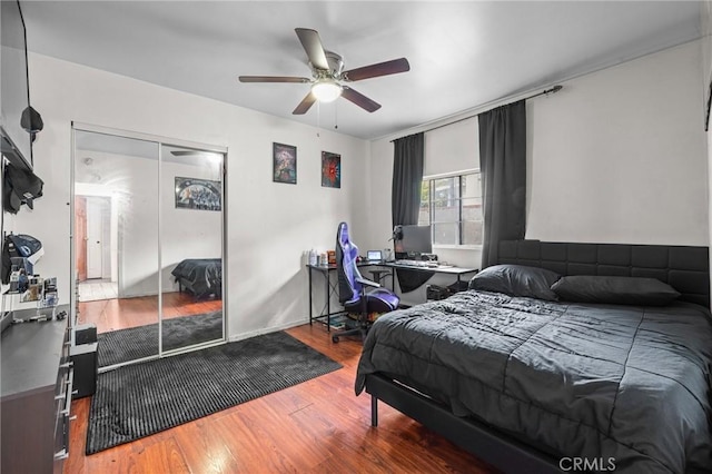 bedroom with wood-type flooring, ceiling fan, and a closet