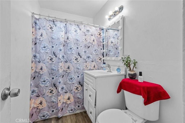 bathroom with hardwood / wood-style floors, vanity, curtained shower, and toilet