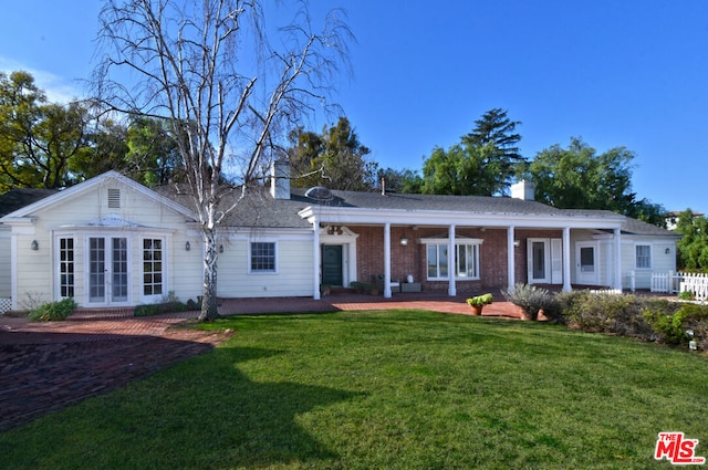 rear view of house featuring a yard