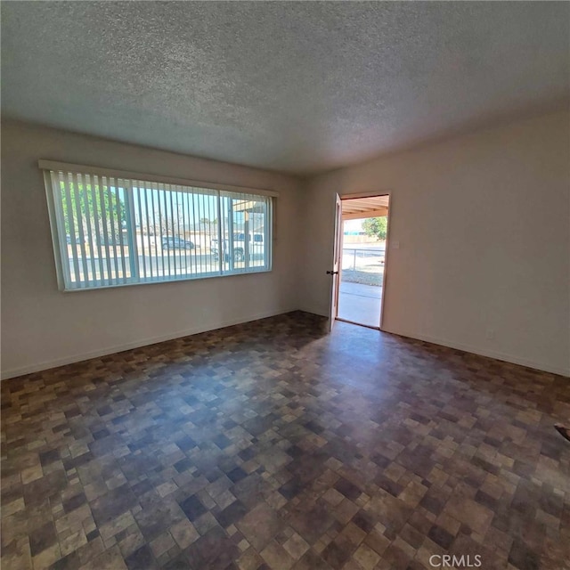 unfurnished room with a textured ceiling